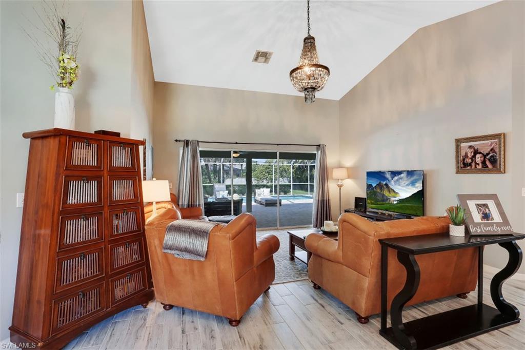 7359 Stonegate Drive Naples, FL 34109 - Photo 13 of 33 a living room with furniture cabinets and a large window