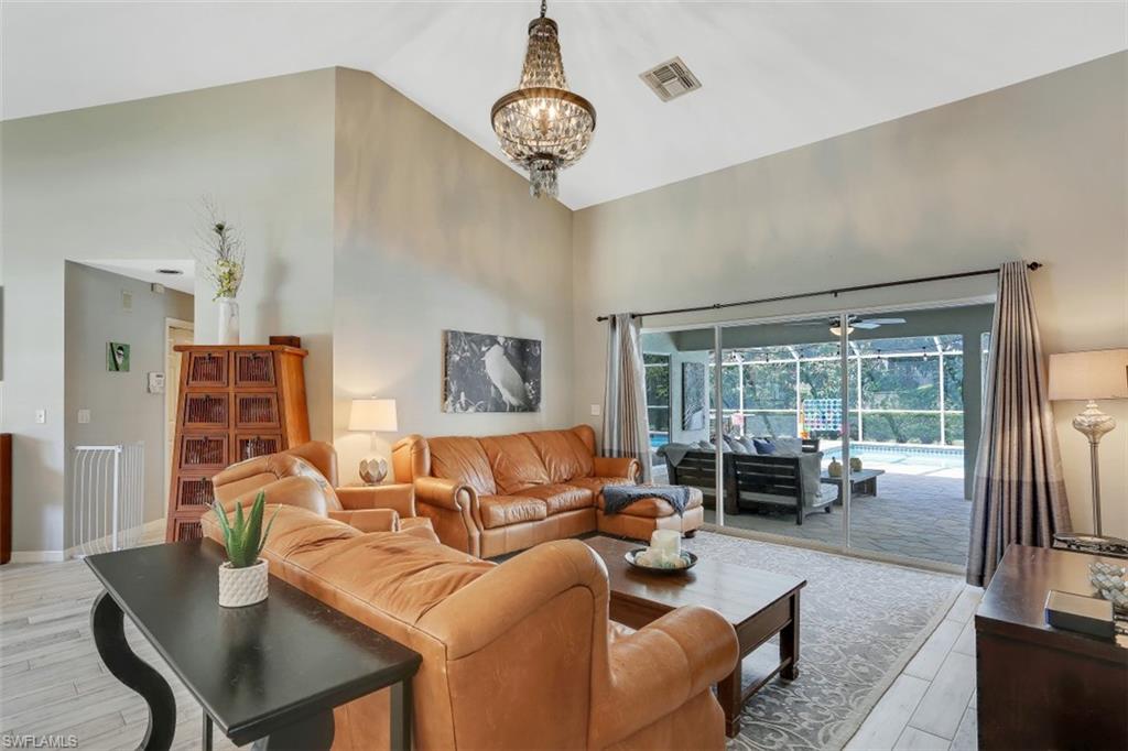 7359 Stonegate Drive Naples, FL 34109 - Photo 14 of 33 a living room with furniture a table and a large window