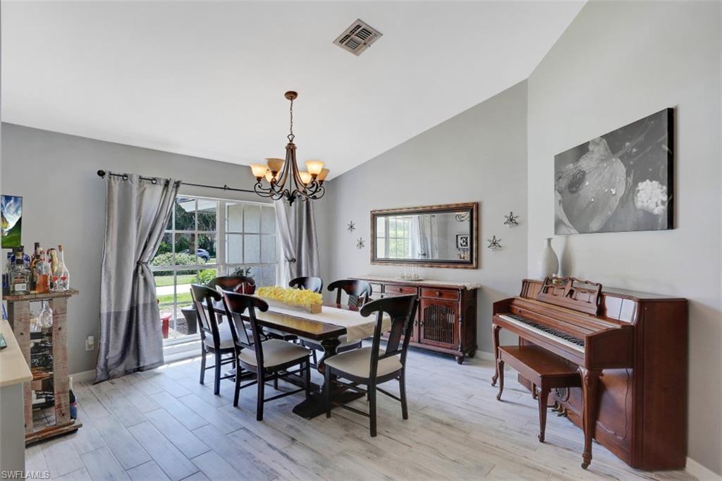 7359 Stonegate Drive Naples, FL 34109 - Photo 15 of 33 a view of a dining room with furniture window and wooden floor