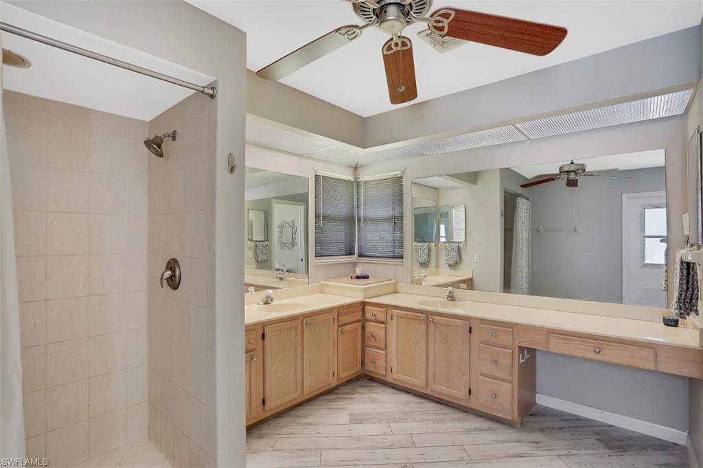 7359 Stonegate Drive Naples, FL 34109 - Photo 18 of 33 a large bathroom with a double vanity sink mirror and shower