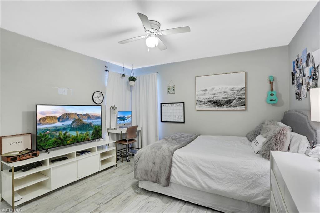 7359 Stonegate Drive Naples, FL 34109 - Photo 19 of 33 a bedroom with a flat screen tv and a ceiling fan