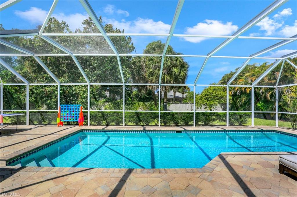 7359 Stonegate Drive Naples, FL 34109 - Photo 3 of 33 a view of a swimming pool with a yard and potted plants