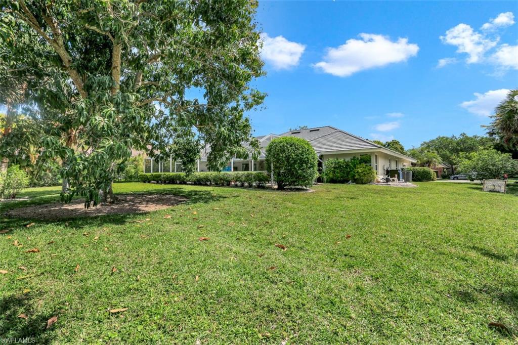 7359 Stonegate Drive Naples, FL 34109 - Photo 31 of 33 a view of a garden with a fountain