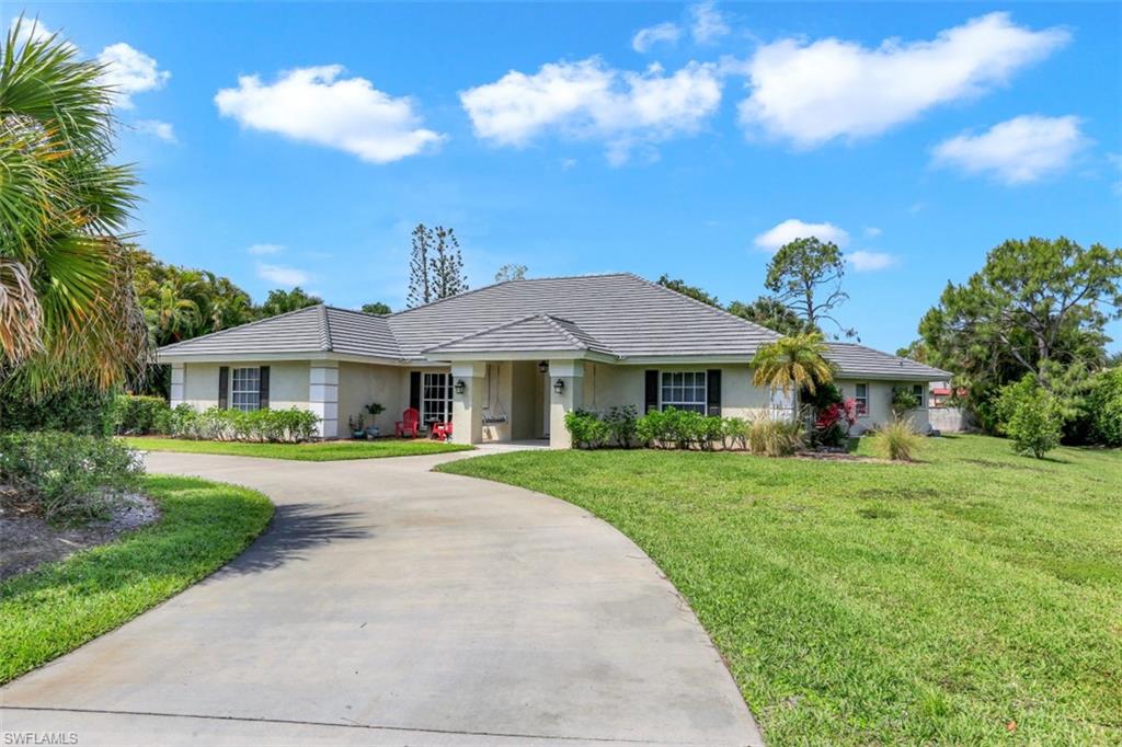 7359 Stonegate Drive Naples, FL 34109 - Photo 33 of 33 a front view of a house with a yard and porch