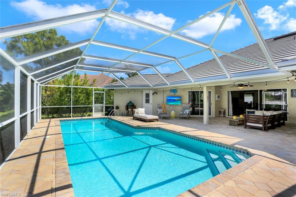 7359 Stonegate Drive Naples, FL 34109 - Photo 4 of 33 a view of a backyard with table and chairs under an umbrella