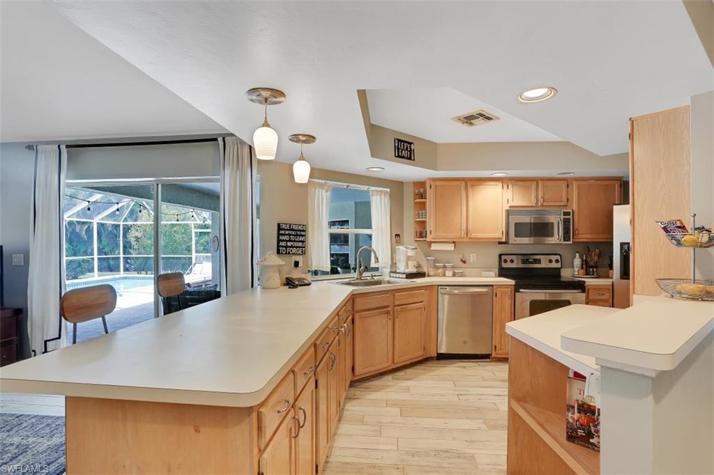 7359 Stonegate Drive Naples, FL 34109 - Photo 9 of 33 a kitchen with sink stove and refrigerator