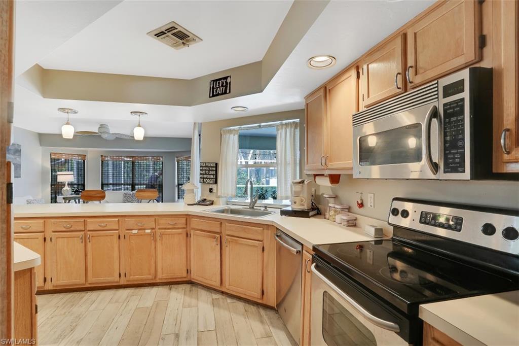 7359 Stonegate Drive Naples, FL 34109 - Photo 10 of 33 a kitchen with a sink a stove and cabinets