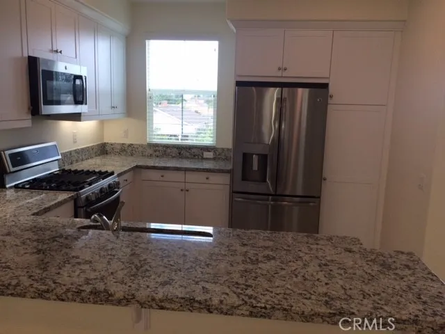 a kitchen with a refrigerator and a stove top oven