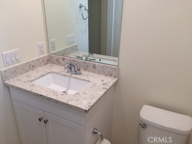 1613 East Lincoln Avenue Anaheim, CA 92805 - Photo 14 of 26 a bathroom with a granite countertop toilet sink and mirror