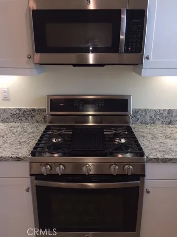 a stove top oven sitting inside of a kitchen