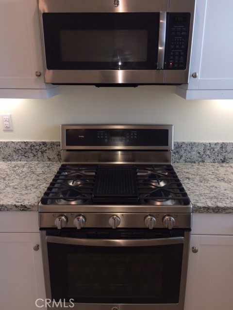 1613 East Lincoln Avenue Anaheim, CA 92805 - Photo 10 of 26 a stove top oven sitting inside of a kitchen