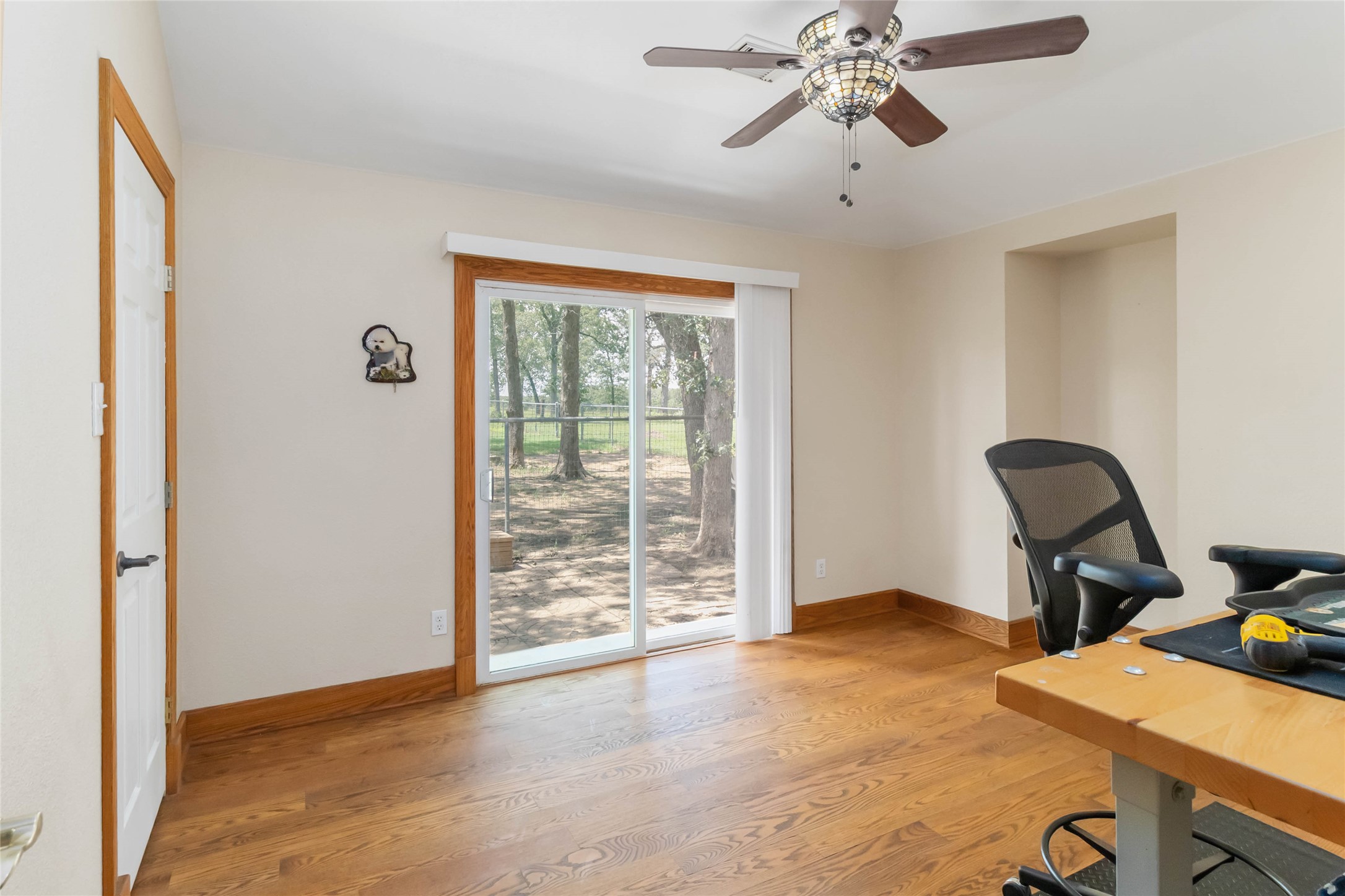 1208 Jeddo Road Rosanky, TX 78953 - Photo 22 of 40 Hardwood flooring extends throughout this versatile space, featuring a glass sliding door for abundant natural light.