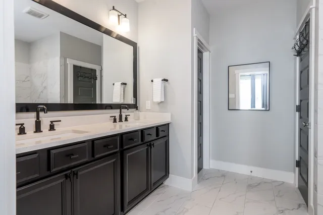 a bathroom with a double vanity sink and a mirror