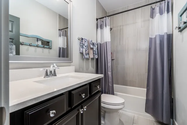 a bathroom with a sink a toilet a mirror and shower