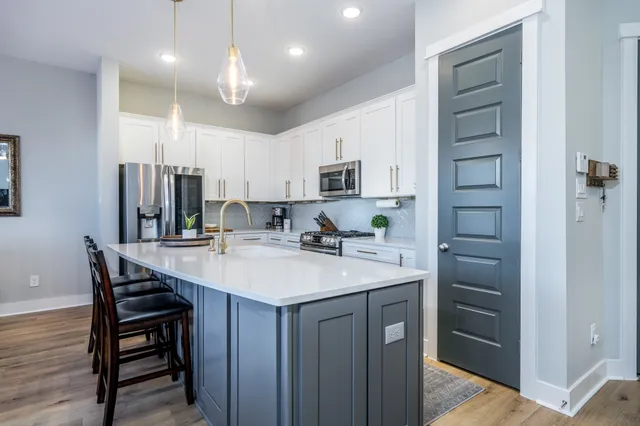 a kitchen with kitchen island a wooden floor and white cabinets