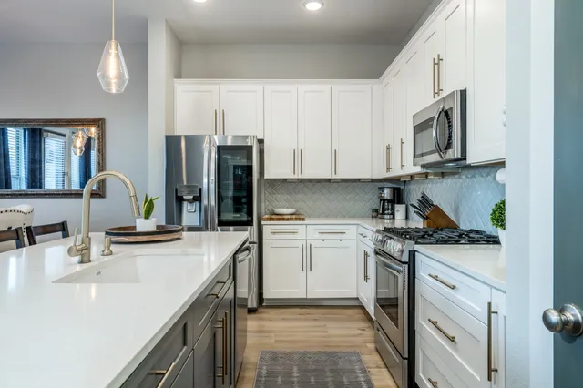 a kitchen with stainless steel appliances granite countertop a sink stove and refrigerator