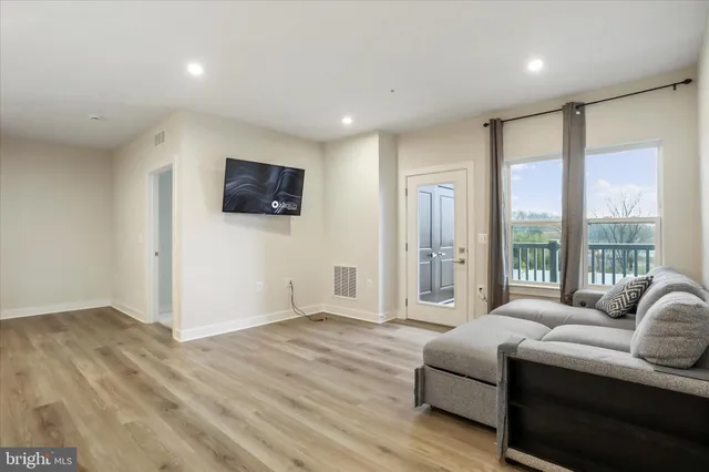 a living room with furniture a large window and a flat screen tv