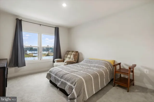 a bedroom with a bed and a large window
