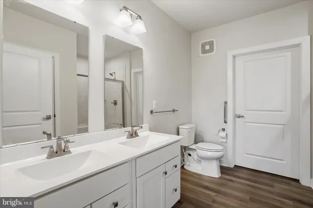 a bathroom with a double vanity sink toilet and a mirror