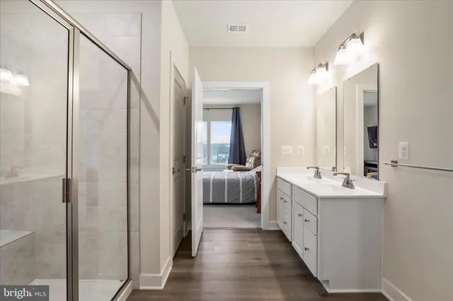 a bathroom with a double vanity sink mirror and shower