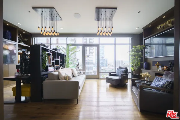 a living room with patio furniture and a chandelier