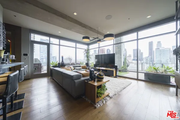 a living room with furniture a flat screen tv and a large window