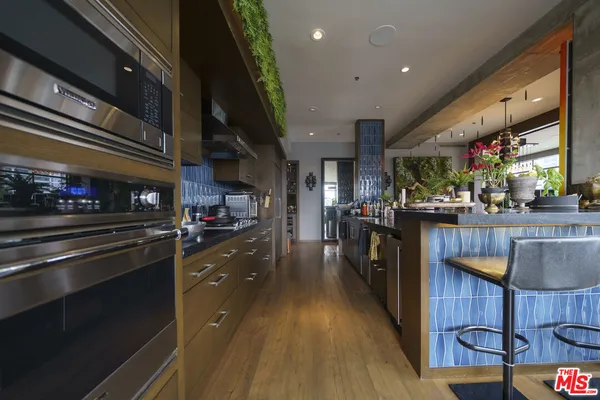 a kitchen with stainless steel appliances kitchen island granite countertop a stove and cabinets