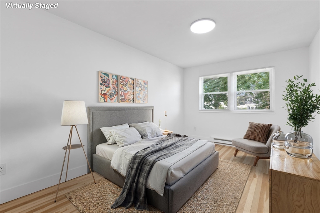 303 Broadway, Unit C2 Lynn, MA 01904 - Photo 1 of 15 a bedroom with a bed and wooden floor