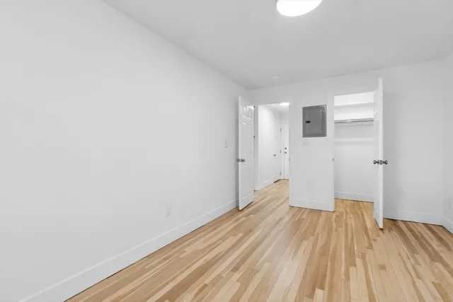 a view of a room with wooden floor and a ceiling fan