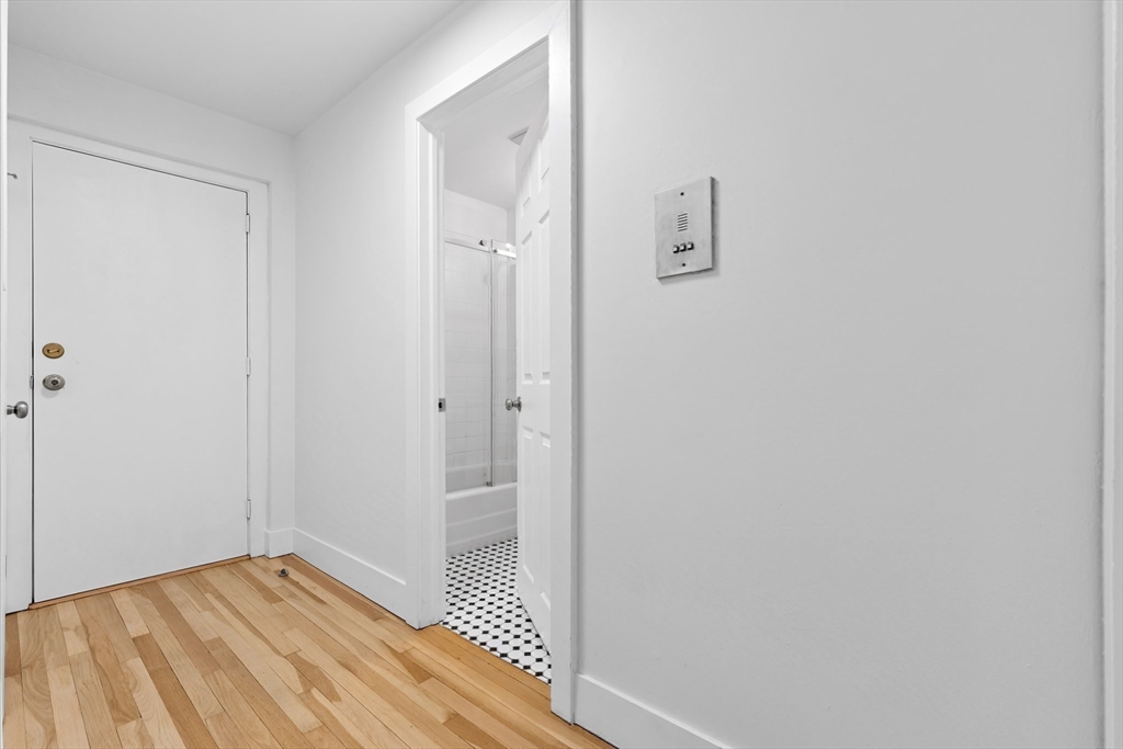 303 Broadway, Unit C2 Lynn, MA 01904 - Photo 13 of 15 a view of a hallway with wooden floor and a bathroom
