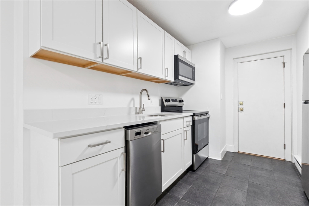 303 Broadway, Unit C2 Lynn, MA 01904 - Photo 4 of 15 a kitchen with stainless steel appliances granite countertop a sink and a refrigerator
