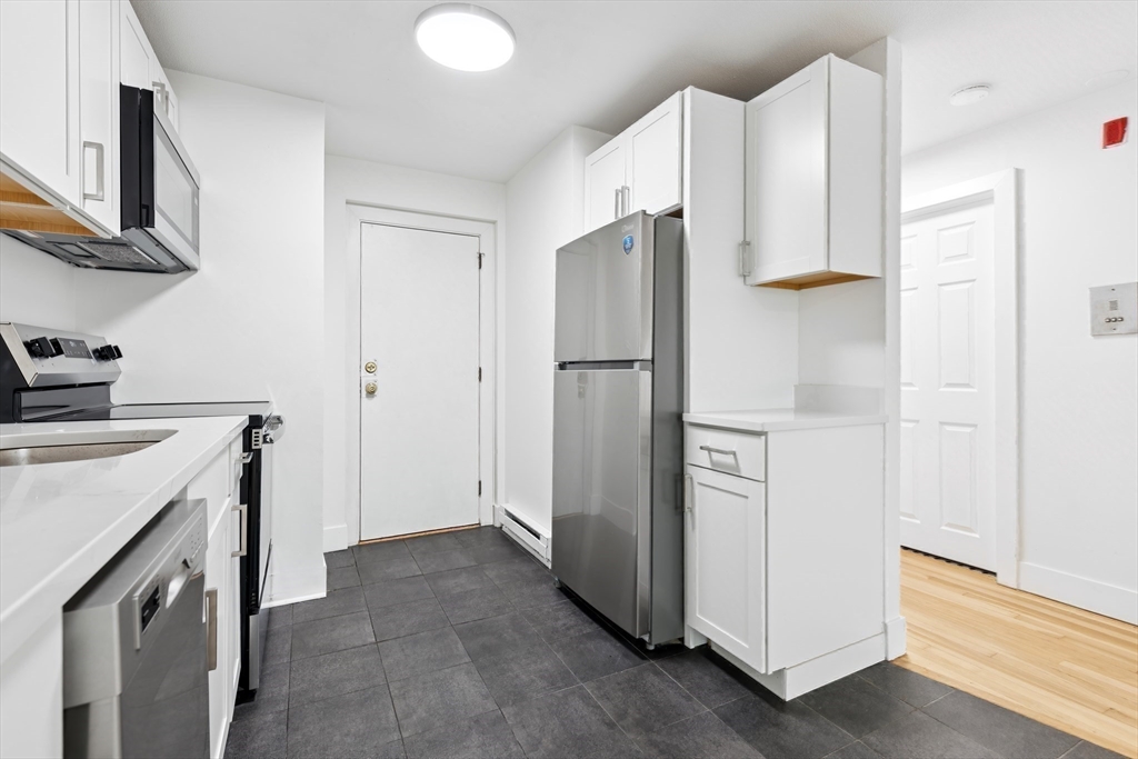 303 Broadway, Unit C2 Lynn, MA 01904 - Photo 6 of 15 a kitchen with a refrigerator sink stove and cabinets