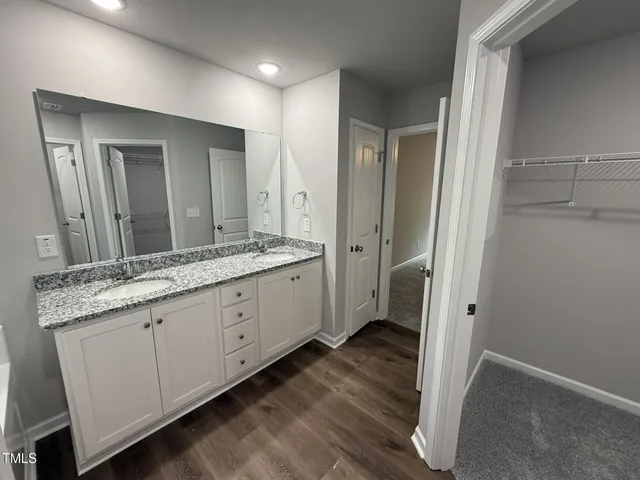 a spacious bathroom with a granite countertop sink mirror and a toilet