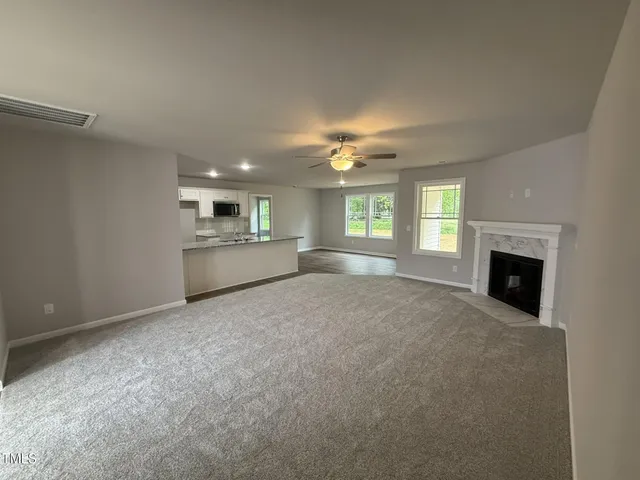 a view of an empty room with a window and fireplace