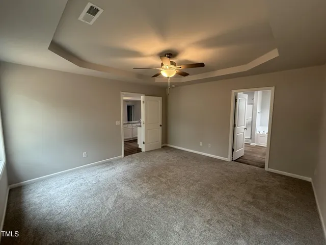 an empty room with a ceiling fan and a window