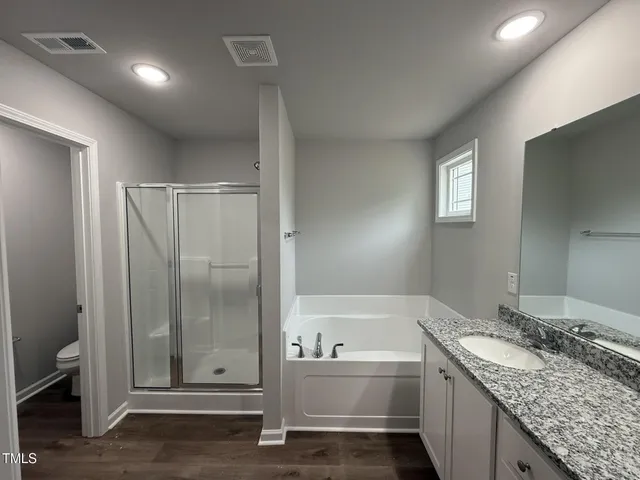 a bathroom with a granite countertop sink and mirror with bathtub