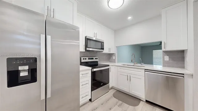 a kitchen with stainless steel appliances a sink stove and refrigerator