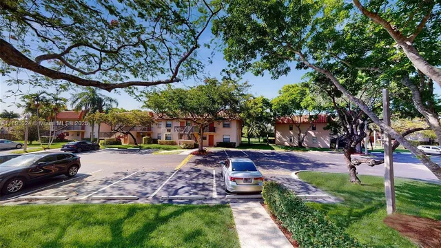a view of a yard with a table and chairs under an umbrella