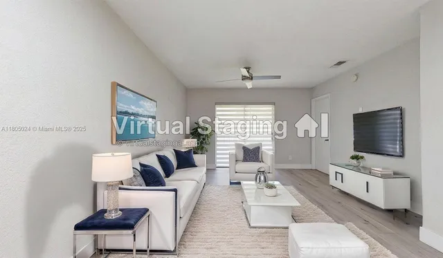 a living room with furniture a flat screen tv and a large window