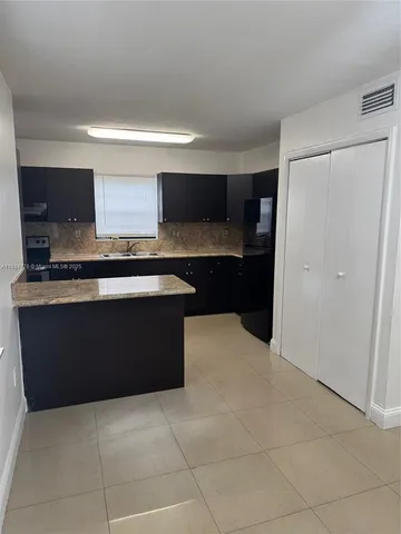 a kitchen with stainless steel appliances a sink and a refrigerator