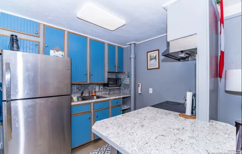 a kitchen with stainless steel appliances granite countertop a refrigerator and a stove top oven