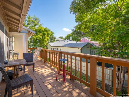 a view of a balcony with wooden floor and outdoor seating