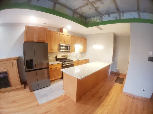 a large kitchen with stainless steel appliances a refrigerator and a stove