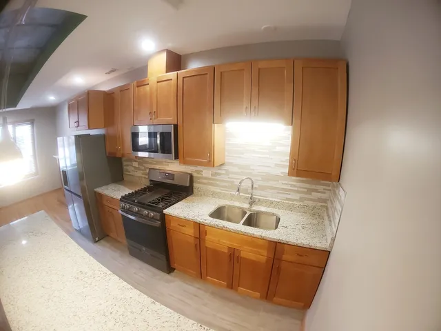 a kitchen with stainless steel appliances granite countertop a sink stove and refrigerator