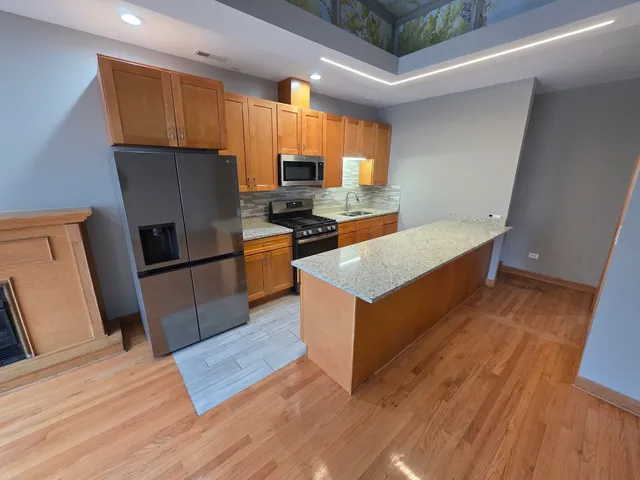 a kitchen with stainless steel appliances granite countertop a stove a sink and a microwave