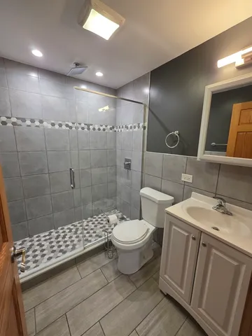 a bathroom with a toilet a sink and mirror
