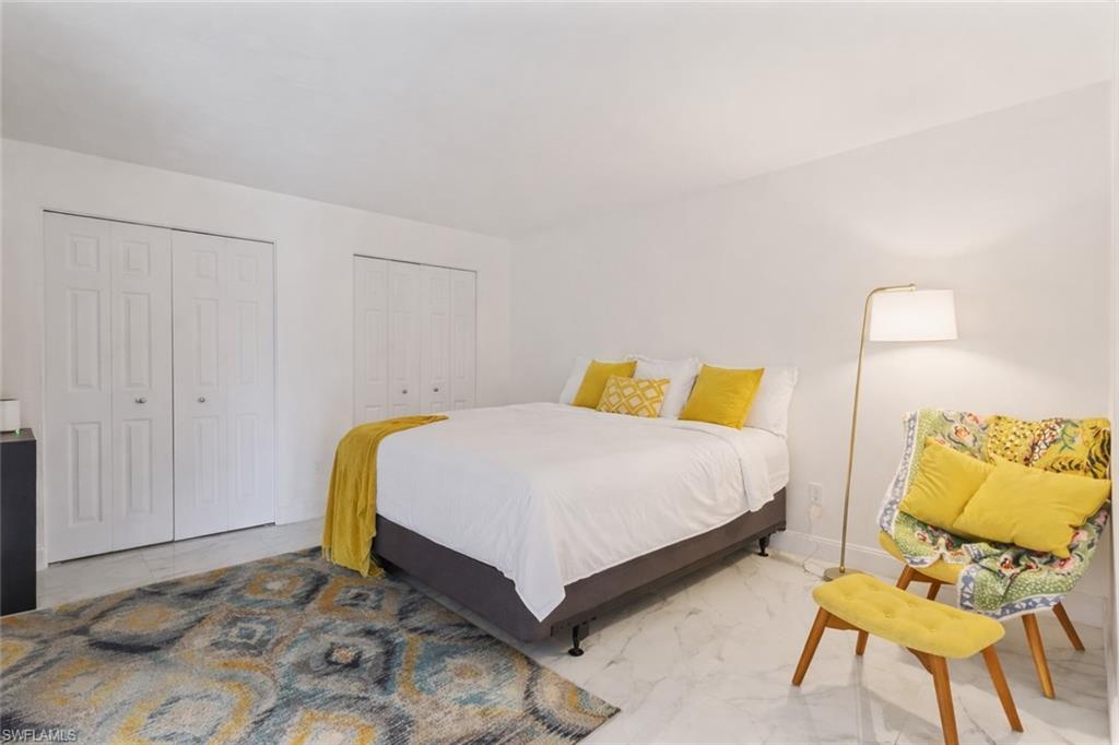 452 Bristle Cone Lane, Unit 27 Naples, FL 34113 - Photo 11 of 16 Bedroom with two closets and light marble finish flooring