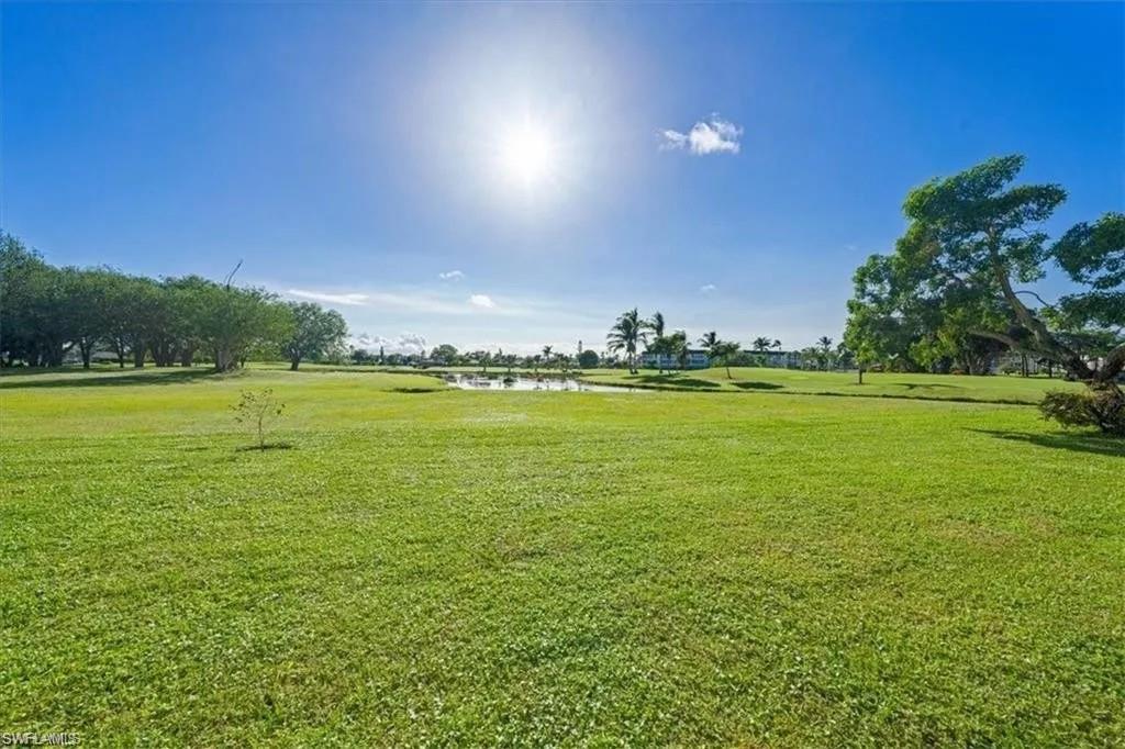 452 Bristle Cone Lane, Unit 27 Naples, FL 34113 - Photo 13 of 16 View of green lawn with a water view