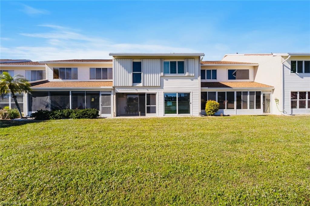 452 Bristle Cone Lane, Unit 27 Naples, FL 34113 - Photo 16 of 16 Rear view of house featuring a sunroom and a yard