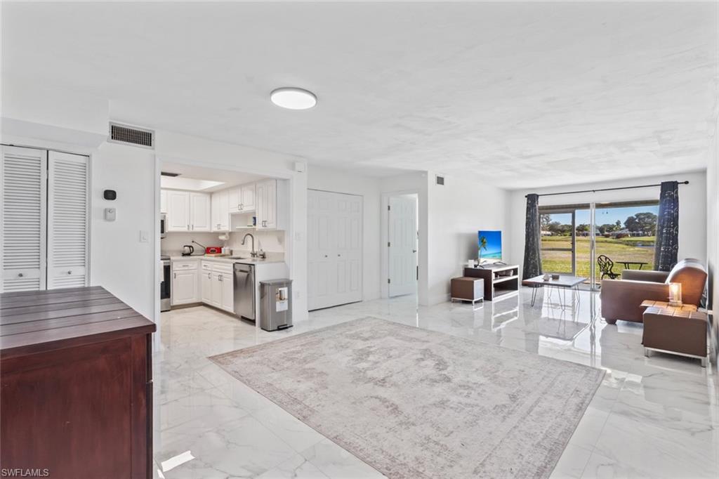 452 Bristle Cone Lane, Unit 27 Naples, FL 34113 - Photo 5 of 16 Living area with light marble finish flooring
